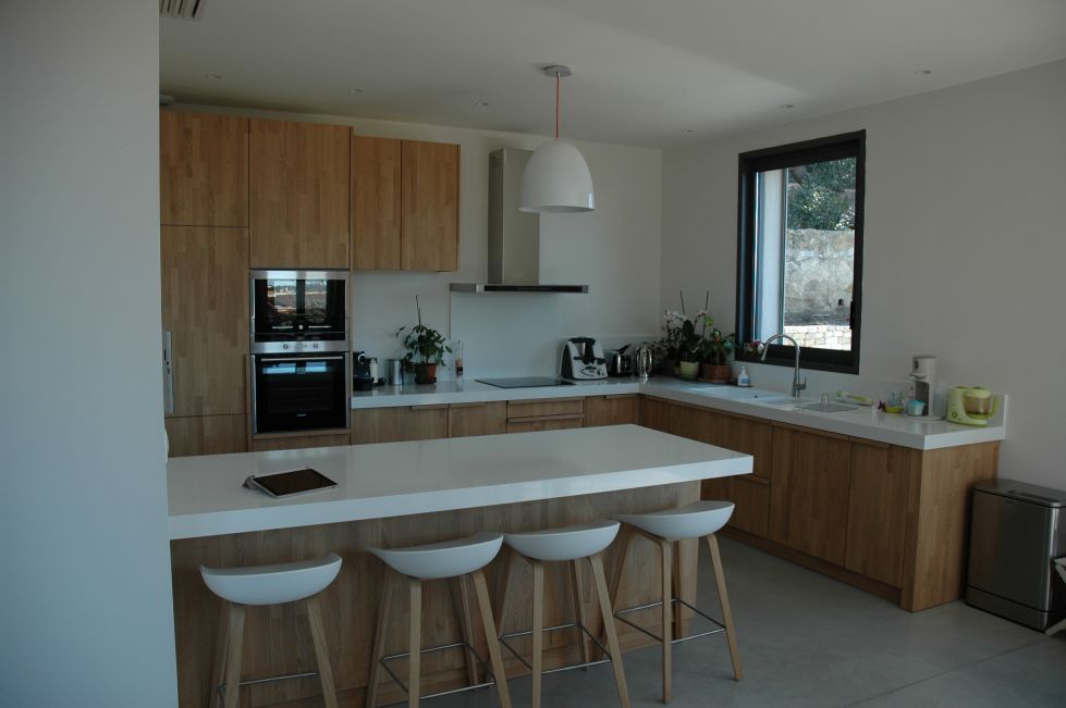 En façade, portes, façades de tiroirs, plinthes et côtés de meubles réalisés en lamellé collé chêne épaisseur 20 mm, fini verni